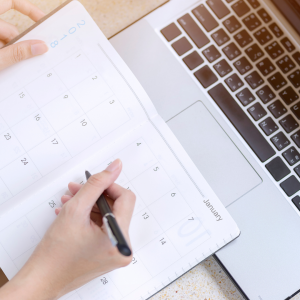 An overhead shot of someone filling in a planner.